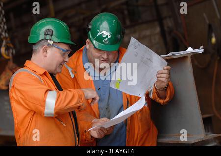 Engineers consulting plans, blueprints and schematics. Stock Photo