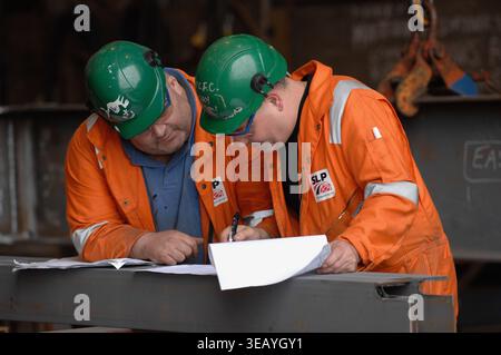 Engineers consulting plans, blueprints and schematics. Stock Photo