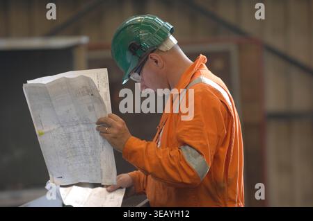 Engineers consulting plans, blueprints and schematics. Stock Photo