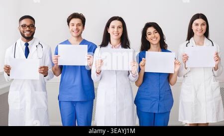 Doctors And Interns Holding Empty Papers, Standing In Hospital Stock Photo