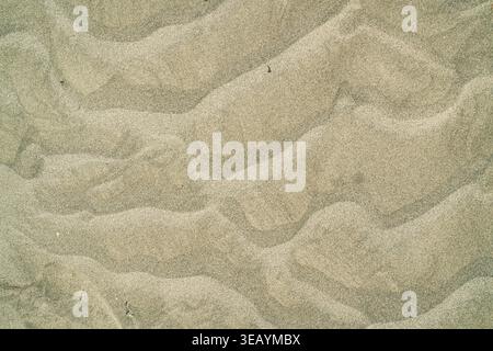 Sand ripples showing natural textures and patterns, created by wind and water on a beach, providing an abstract background for design or nature concep Stock Photo