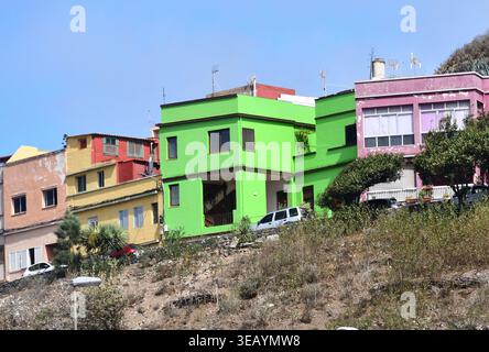 Vibrant colorful terraced houses on a hillside in a traditional Canary Islands village under a clear blue sky Stock Photo