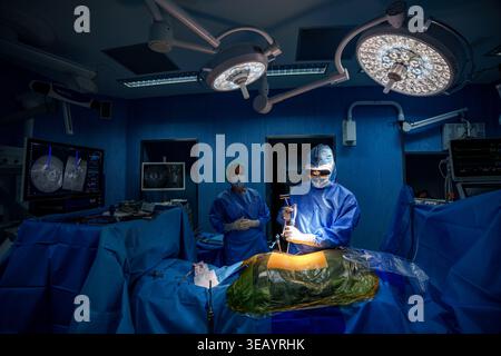 Surgeon wearing MediThinQ Scopeye smart glasses during a spine surgery in a high-tech operating room Stock Photo