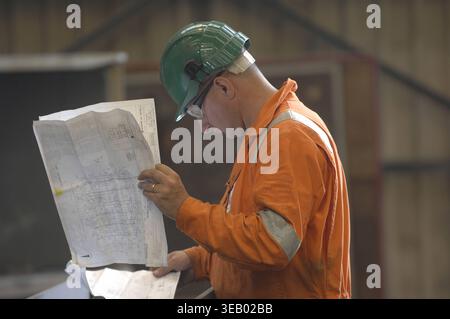 Engineers consulting plans, blueprints and schematics. Stock Photo