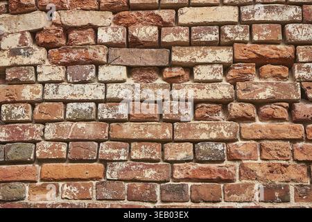 Old red brick wall background, uneven brickwork Stock Photo