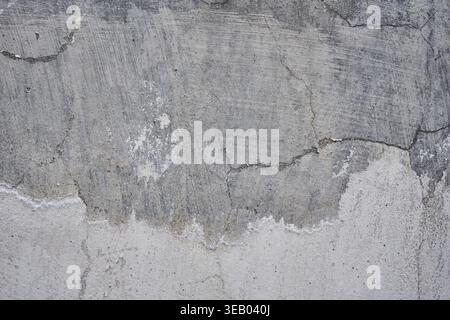 Concrete wall with crack, gray color background, removing plaster from a cement wall, rough surface texture. Renovation of old residential premises an Stock Photo