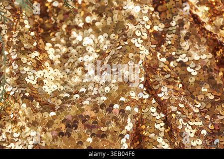 Waves of brightly shiny fabric with large gold sequins. Festive rich textiles glitter mesh for dresses., texture background Stock Photo