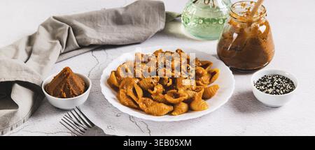 Spicy miso pasta shells on a plate on the table web banner Stock Photo