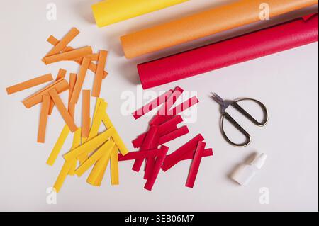Strips of colored paper, scissors and glue to make paper garlands top view Stock Photo