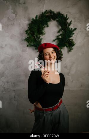 Joyful Woman with Candy Cane Wearing Red Beret Stock Photo