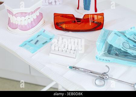 Various instruments, dental models, and hygiene items are laid out on the table in the dental office. natural light Stock Photo