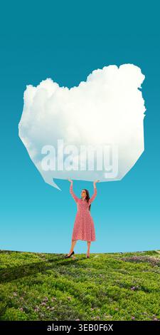 Woman holding large speech bubble cloud above head symbolizing communication and ideas Stock Photo