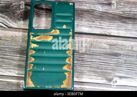 Cairo, Egypt, April 11 2026: A Well-worn green phone case appears to be a generic leather or silicone bumper cover designed for mobile phones like the Stock Photo