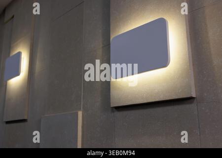 Modern illuminated wall lamp on textured interior wall in office conference space Stock Photo