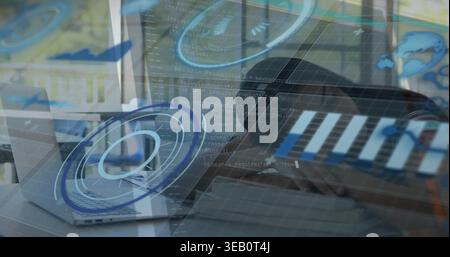 Typing teenage female wearing dark hoodie at desk, hands on keyboard, silver laptop, code HUD Stock Photo