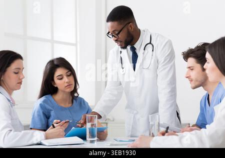 Successful Medical Team Discussing Diagnosis At Conference Stock Photo