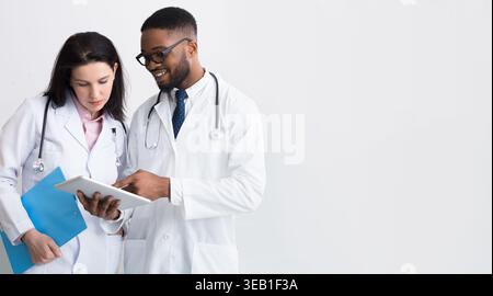 Two doctors in white coats discussing diagnosis Stock Photo