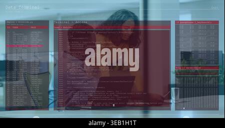 Leaning woman in yellow top studying laptop at office desk, with terminal overlay and coffee mug Stock Photo