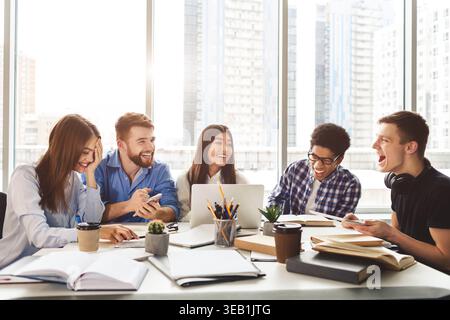 University students sitting together at table with books and laptop Stock Photo