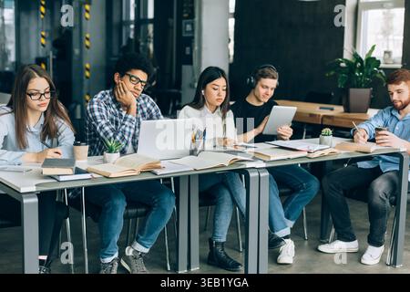 Group of Students Studying Together in a Modern Workspace During the Afternoon Stock Photo