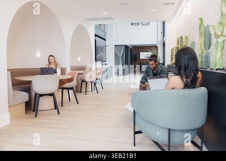 People Collaborating In Bright Space. Open Lounge With Vibrant Teamwork Atmosphere. Multiple Individuals Engaging In Creative Collaboration Within Stock Photo