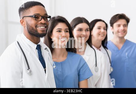 Team of doctors and interns standing in hospital in row Stock Photo
