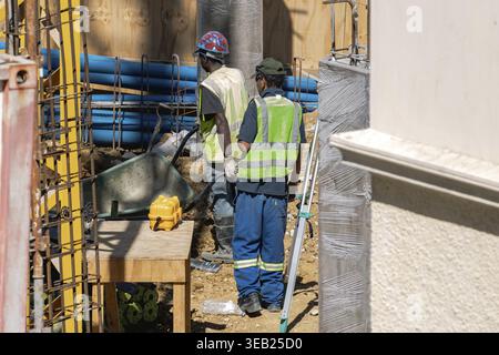 Two workers in uniform and reflective vest at a construction site Stock Photo