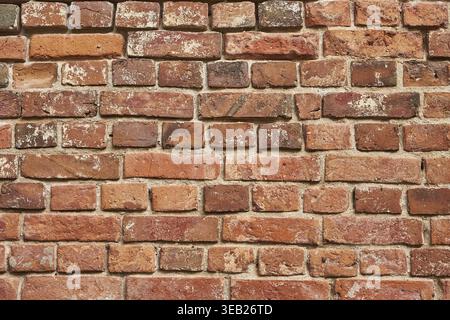 Old red brick wall background, uneven brickwork Stock Photo