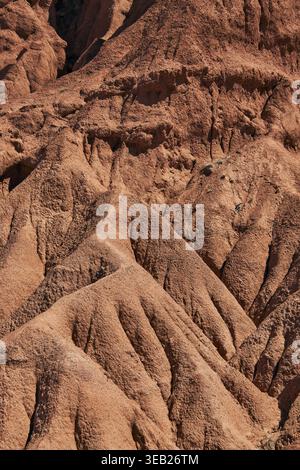 Abstract natural background, red rugged sandstone. eroded soil close up. dry climate, erosion, canyon area Stock Photo