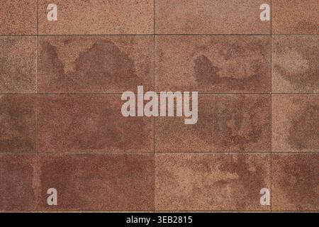 Granite tile wall, bricks, memorial cladding. Even rectangular red blocks, background. smooth surface of treated natural stone Stock Photo
