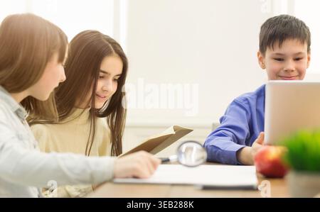 Preteen Children Doing Homework In Classroom At School Stock Photo