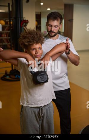 Young African American male exercising with kettlebell indoors Stock Photo