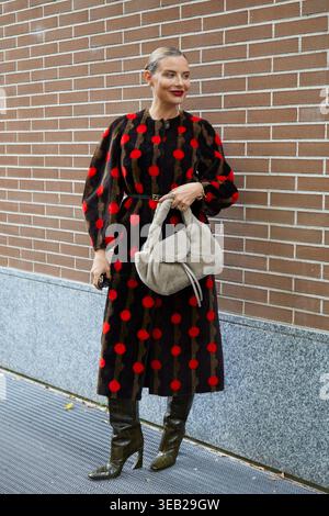 MILAN, ITALY - SEPTEMBER 24, 2025: Veronica Ferraro with dress with red dots on black and brown background before Fendi fashion show, Milan Fashion We Stock Photo