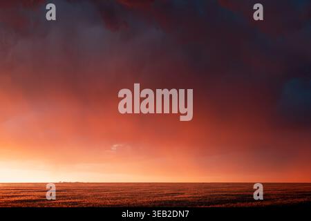 Dramatic sunset sky over a farm field in the Great Plains Stock Photo