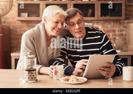 Couple Enjoying Leisure Time Together While Using a Digital Tablet in a Cozy Cafe Setting Stock Photo