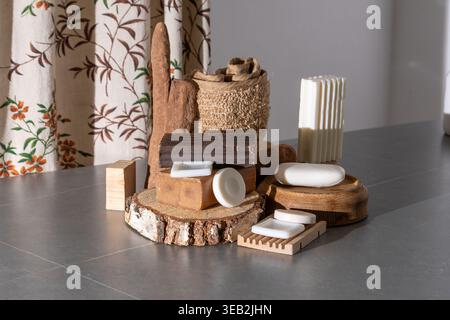 Natural Soap Bars Collection on Wooden Podiums with Rustic Bath Accessories. Assortment of Soaps and Loofah still life Stock Photo