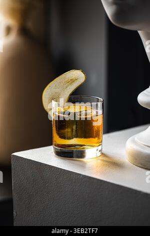 Whiskey cocktail with pear garnish in glass Stock Photo