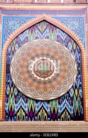 A colorful Uzbek pattern decorating a wall, hand-painted close-up in an oriental style. The concept is Uzbek national traditions Stock Photo