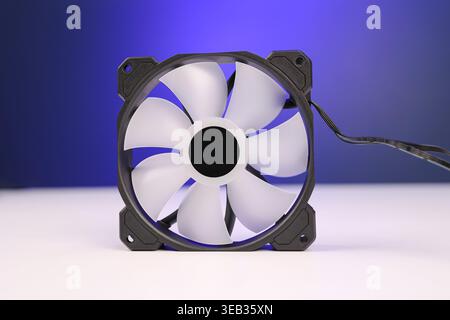 A 120mm Desktop Computer rear Fan closeup shot, on a white table with blue background. (This device maintains the airflow of a PC) Stock Photo