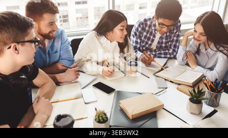 Students reading reference books for study notes Stock Photo
