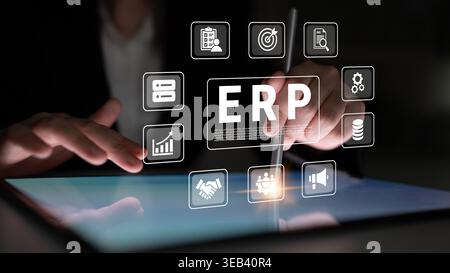 A business professional interacts with digital ERP icons displayed on a tablet screen, showcasing modern solutions for efficient management and Stock Photo