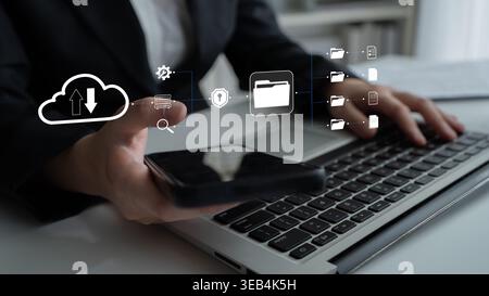 Professional Business Person Using Mobile Phone and Laptop for Cloud Data Management and File Storage Visualization in Modern Office Quark. Stock Photo