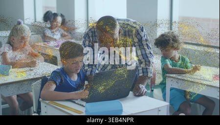 Leaning teacher wearing plaid shirt helping student on laptop in classroom with pencil case Stock Photo