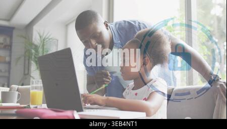 Guiding father in denim with pencil leaning over child using laptop at home with padlock-icon Stock Photo