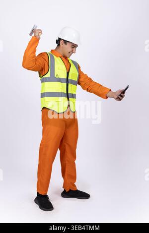 Construction worker in safety vest holding tools Stock Photo