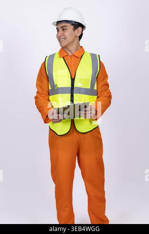 Construction worker in orange uniform holding a tablet Stock Photo