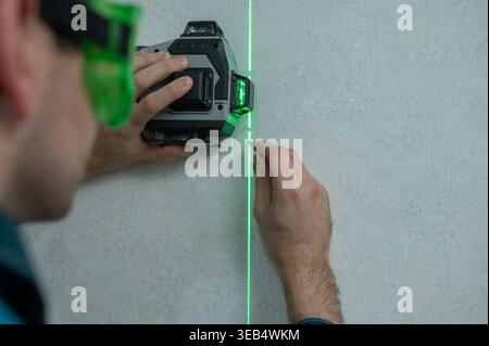 A man measures distance with a laser level.  Stock Photo