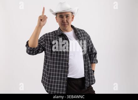 Man in a hat pointing upwards with a serious expression Stock Photo