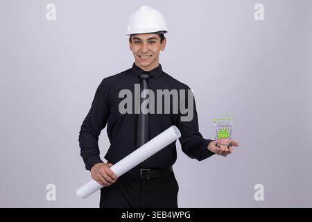 Engineer in hard hat holding blueprints and device Stock Photo