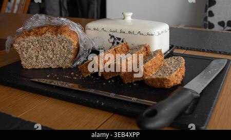 Different types of artisanal Irish bread and sliced loaves displayed on a wooden table outdoors. Stock Photo